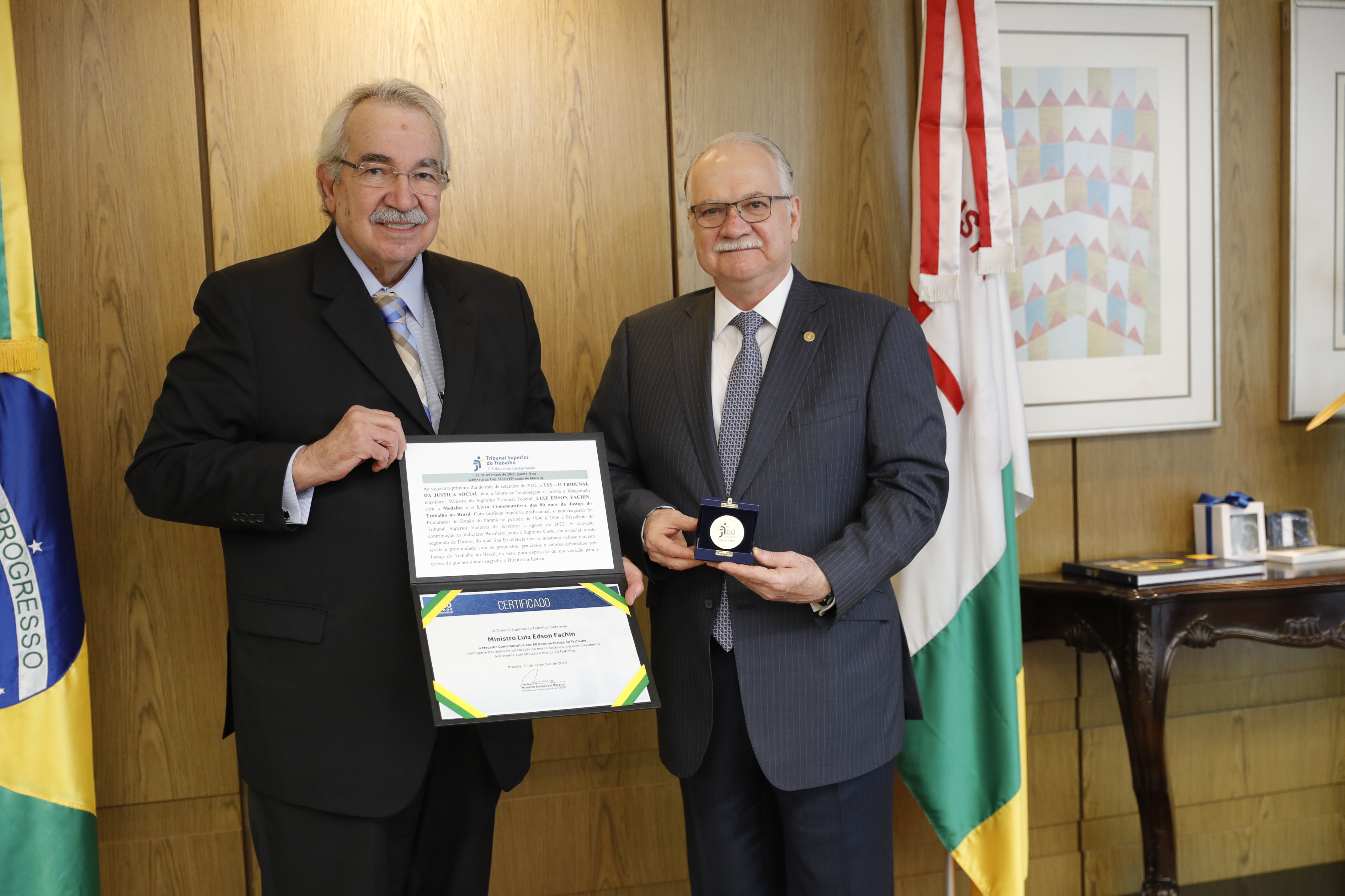 Ministros Emmanoel Pereira e Edson Fachin mostrando a medalha dos 80 anos da Justiça do Trabalho