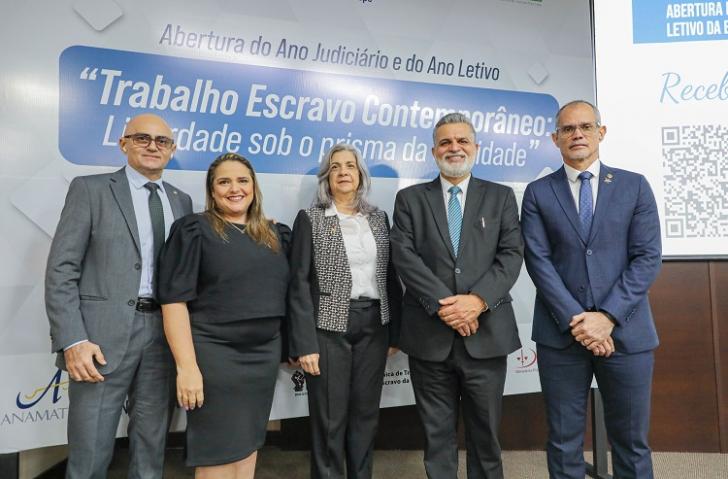 #ParatodosVerem: Fotografia em ambiente fechado com cinco pessoas lado a lado. Do lado direito, um homem alto, magro, usa óculos e paletó na cor azul, ao seu lado esquerdo, um homem alto, cabelos e barbas grisalhos, usa paletó preto. Ao centro duas mulheres, uma branca, cabelos brancos, usa blusa branca e casaco preto com detalhes branco, ao lado esquerdo uma mulher branca de cabelos dourados e usa roupa preta. Do lado esquerdo um homem branco, usa óculos e paletó na cor cinza. Fim da descrição. 